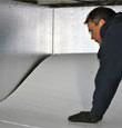 contractor installing TerraBlock™ floor insulation in a Kerrville crawl space