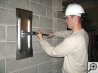 Attempting to straighten a bowed foundation wall by straightening a wall anchor system in a Kerrville home.
