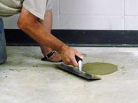 Repairing the cored holes in the concrete slab floor with fresh concrete and cleaning up the Kerrville home.