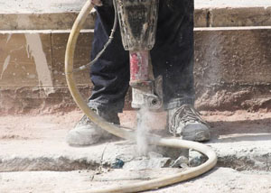 Jackhammering a slab floor in a Seguin home.