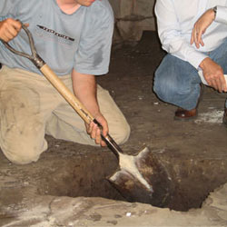 Digging a hole for the engineered fill used in a crawl space support system installation in Del Rio