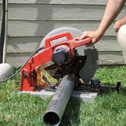 Cutting the support beam for a crawl space jack post outside a Kerrville home.