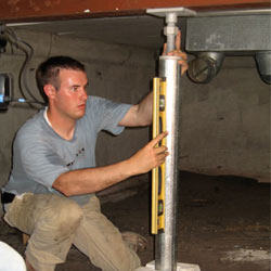 A contractor in Boerne installing a crawl space jack post.