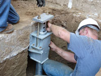 Foundation repair contractors installing the foundation bracket in Laredo.