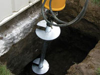 Installing a helical pier system in the earth around a foundation in New Braunfels