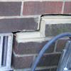A closeup of a failed tuckpointing job where the brick cracked on a Pipe Creek home.