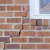 long jagged cracks starting at the corner of a window along a brick wall on a Lockhart home