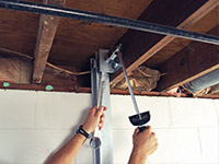 Straightening a foundation wall with the PowerBrace™ i-beam system in a Beeville home.