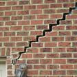 stair step cracking reaching from a window along the foundation wall in New Braunfels