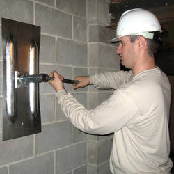 installing a wall anchor to repair an bowing foundation wall in Beeville