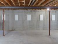 A repaired basement wall with foundation wall anchor covers installed in Seguin.