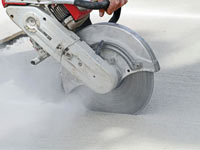 Cutting the driveway for expansion joints during street creep repair in Floresville