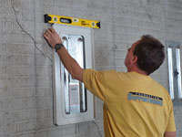 Positioning a wall plate cover on a foundation wall in Del Rio.